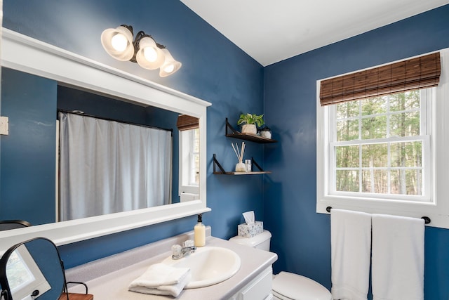 bathroom featuring toilet, a shower with curtain, vaulted ceiling, and vanity