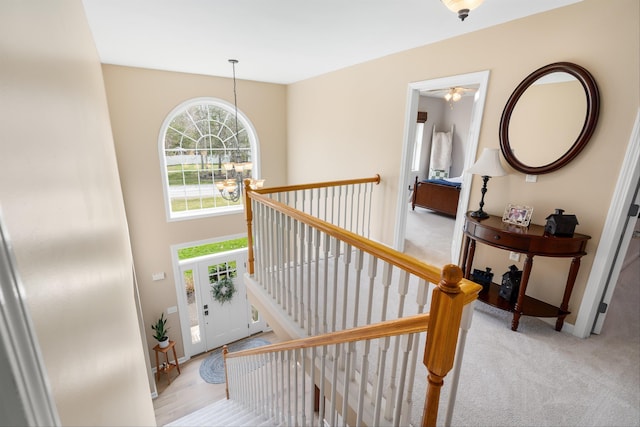 carpeted foyer entrance with baseboards and a notable chandelier