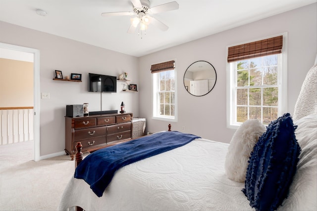 bedroom featuring carpet floors, multiple windows, baseboards, and a ceiling fan