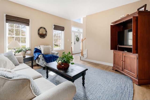 living area with baseboards, baseboard heating, and light wood-style floors
