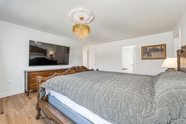 bedroom featuring baseboards, an inviting chandelier, and wood finished floors