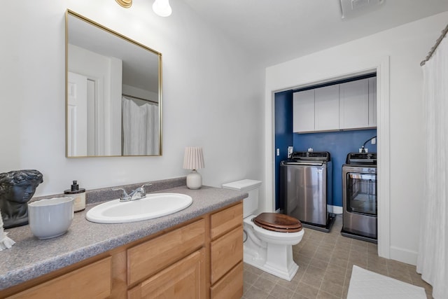 bathroom featuring vanity, tile patterned flooring, visible vents, toilet, and independent washer and dryer