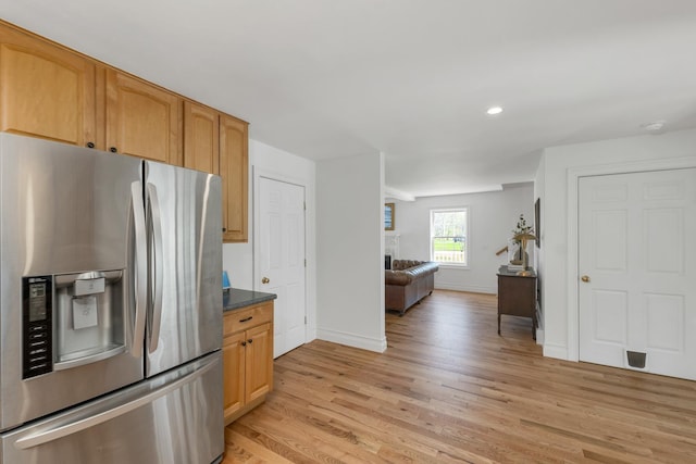 kitchen with baseboards, open floor plan, light wood-type flooring, recessed lighting, and stainless steel fridge with ice dispenser