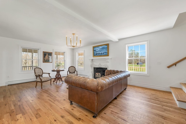 living area featuring a notable chandelier, light wood-style floors, a glass covered fireplace, stairs, and beamed ceiling