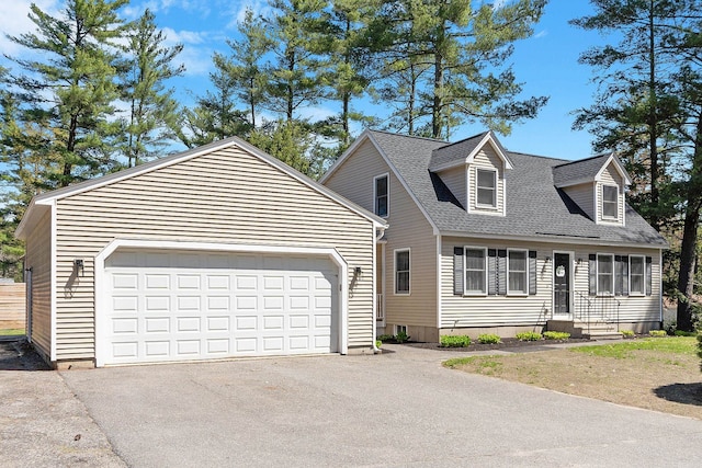 cape cod house featuring a garage, roof with shingles, and driveway