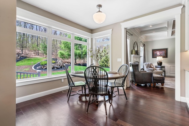 dining room with dark wood-style floors, ornamental molding, a wealth of natural light, and coffered ceiling