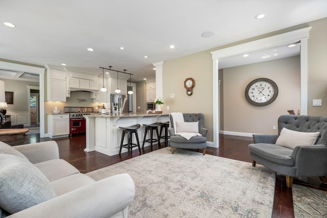 living area featuring recessed lighting, baseboards, and dark wood-style floors
