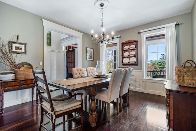 dining room with wainscoting, dark wood-style floors, and a chandelier