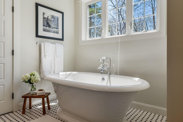 bathroom featuring baseboards and a freestanding tub