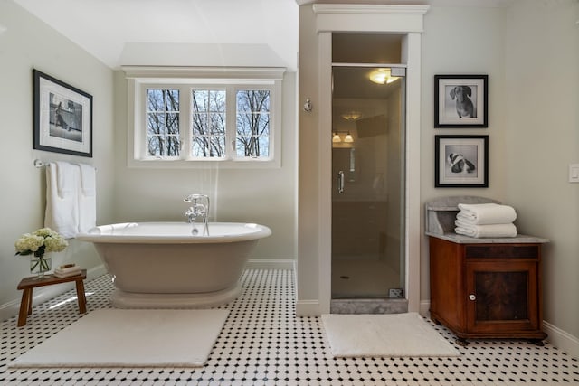 full bathroom with a freestanding tub, baseboards, and a stall shower