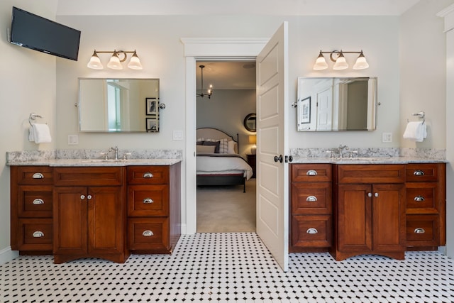 bathroom featuring a sink, two vanities, and ensuite bathroom