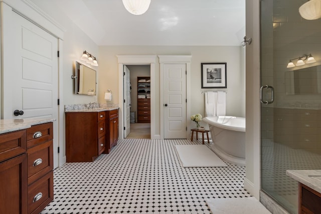 full bath with a freestanding bath, a shower stall, and vanity