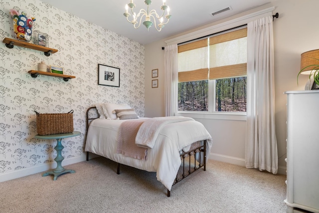 carpeted bedroom with baseboards, wallpapered walls, a chandelier, and visible vents