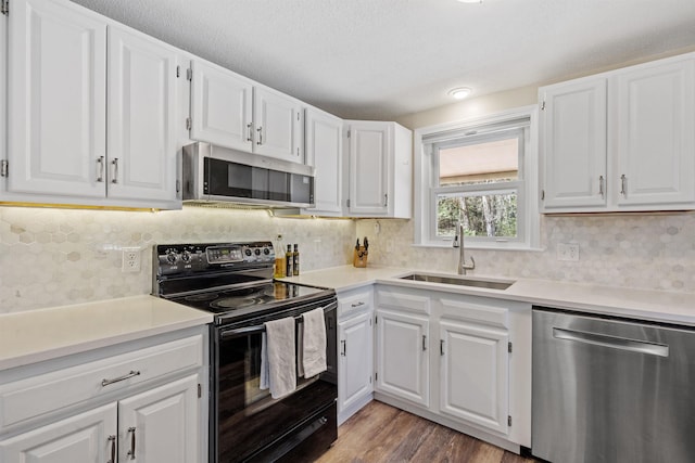 kitchen with light countertops, a sink, white cabinets, and stainless steel appliances