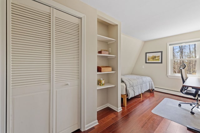 bedroom featuring baseboards, a closet, dark wood-style flooring, and a baseboard heating unit