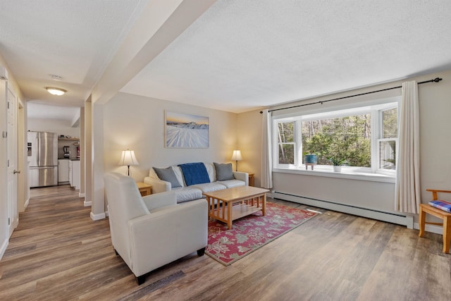 living room with baseboards, a baseboard radiator, a textured ceiling, and wood finished floors