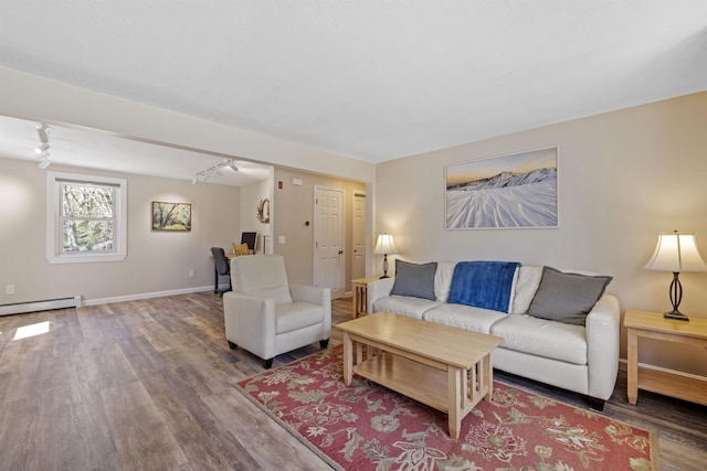 living room featuring baseboard heating, rail lighting, and wood finished floors