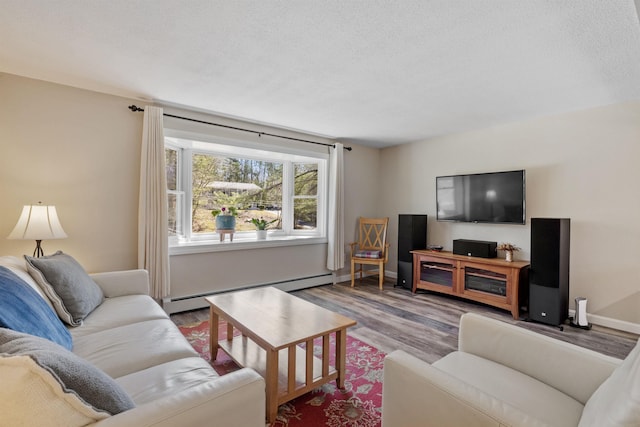 living room with a textured ceiling, baseboards, a baseboard heating unit, and wood finished floors