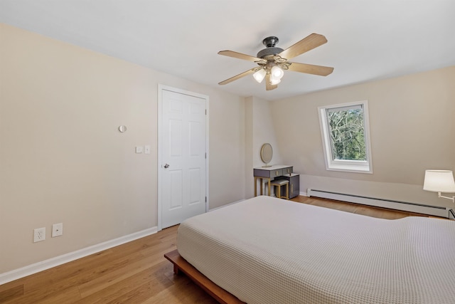 bedroom with ceiling fan, baseboards, a baseboard heating unit, and light wood-style flooring