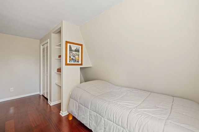 bedroom with baseboards, wood finished floors, and a closet