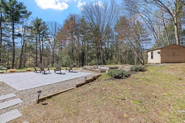 view of yard featuring a patio, an outbuilding, and a shed