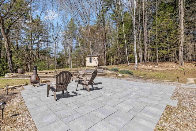 view of patio / terrace with an outdoor structure and a shed