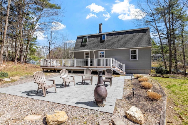 rear view of house featuring a fire pit, a shingled roof, a patio area, and a deck