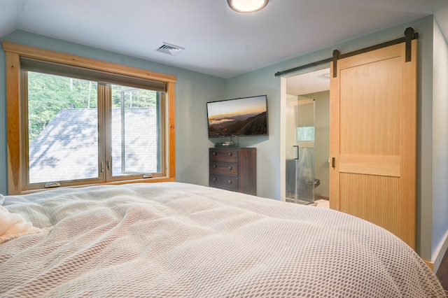 bedroom with visible vents and a barn door