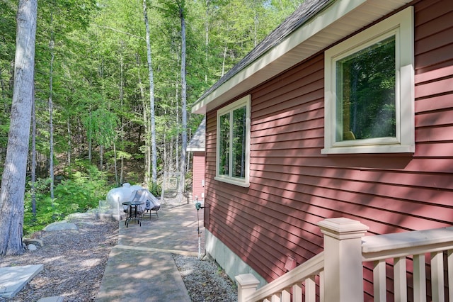 view of property exterior featuring a patio area and a forest view