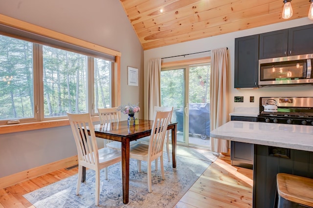 dining room featuring wooden ceiling, vaulted ceiling, plenty of natural light, and light wood-style flooring