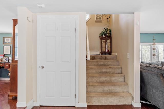 staircase with baseboards and wood finished floors