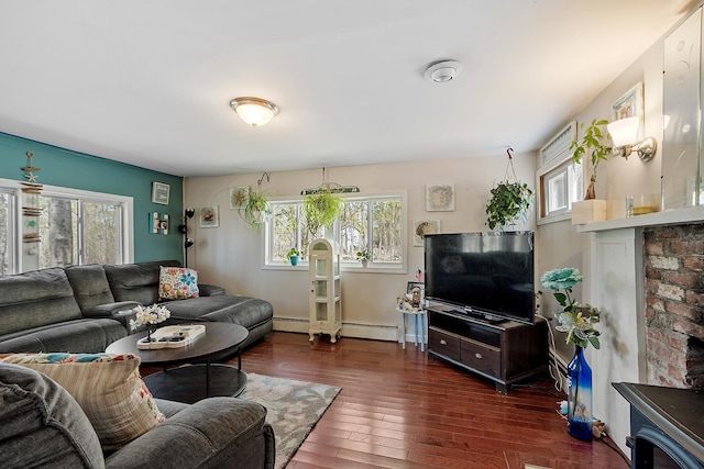 living area featuring dark wood-style flooring, a baseboard heating unit, and plenty of natural light