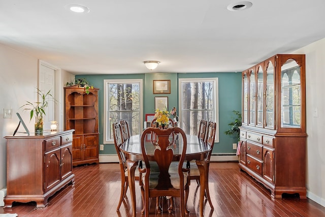 dining room featuring baseboards, baseboard heating, and dark wood-style flooring
