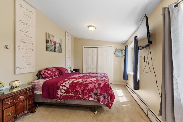 carpeted bedroom with a baseboard heating unit, vaulted ceiling, and a closet