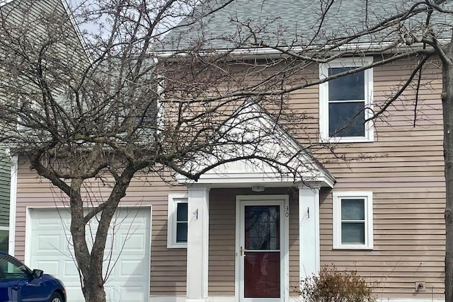 doorway to property with a shingled roof