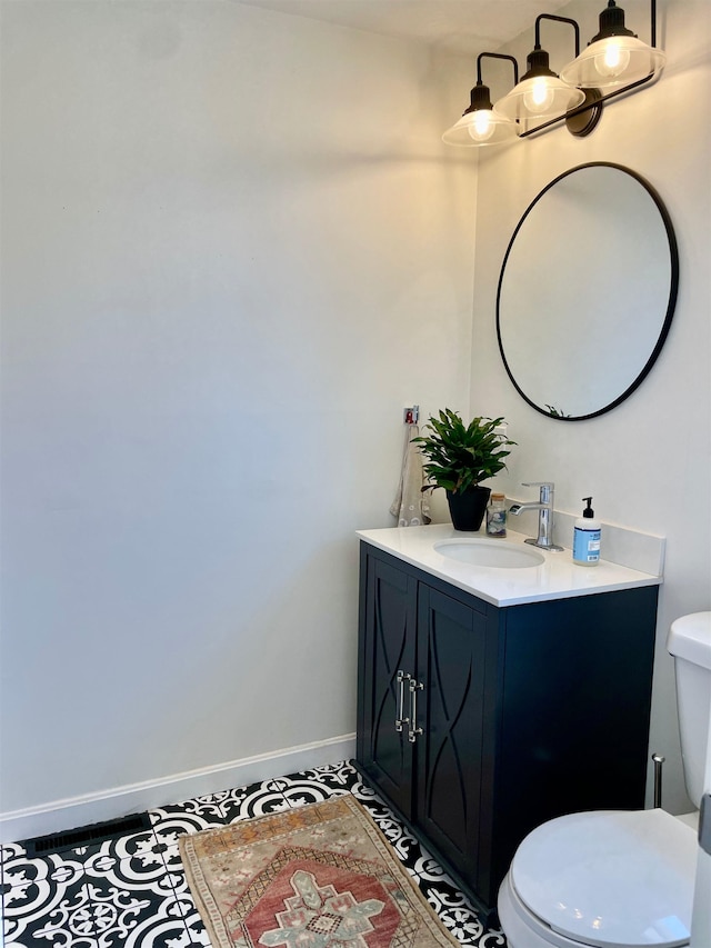 bathroom featuring vanity, baseboards, and toilet