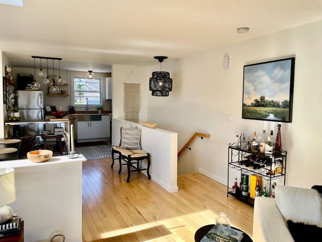 living area featuring light wood-type flooring and baseboards