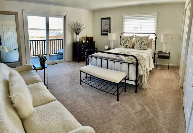 carpeted bedroom featuring access to outside and multiple windows