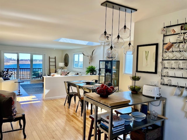 dining room with a skylight and hardwood / wood-style floors
