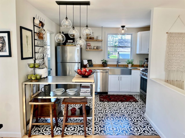 kitchen with open shelves, appliances with stainless steel finishes, a sink, white cabinetry, and pendant lighting