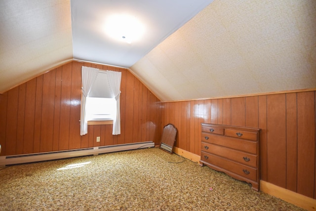 additional living space with vaulted ceiling, carpet floors, a baseboard heating unit, and wooden walls