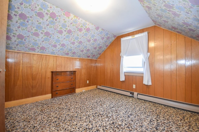 additional living space with wooden walls, a baseboard radiator, wallpapered walls, and lofted ceiling