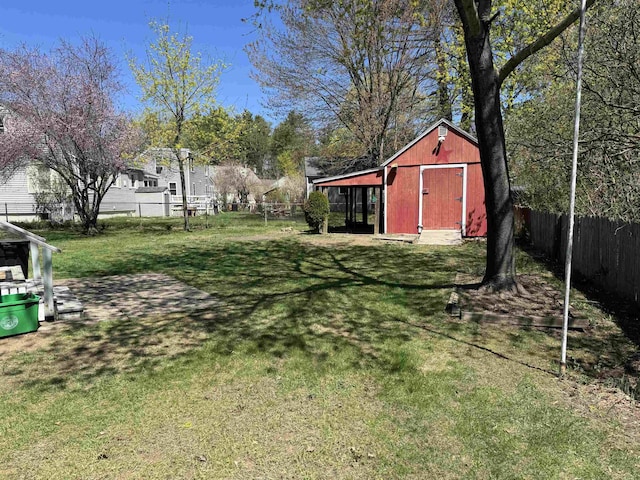 view of yard with an outdoor structure, fence, and a shed