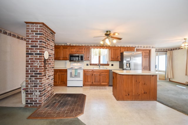 kitchen with a sink, light countertops, stainless steel appliances, a ceiling fan, and a baseboard heating unit