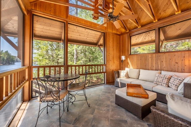 sunroom / solarium with outdoor dining area, beamed ceiling, a ceiling fan, and an outdoor hangout area