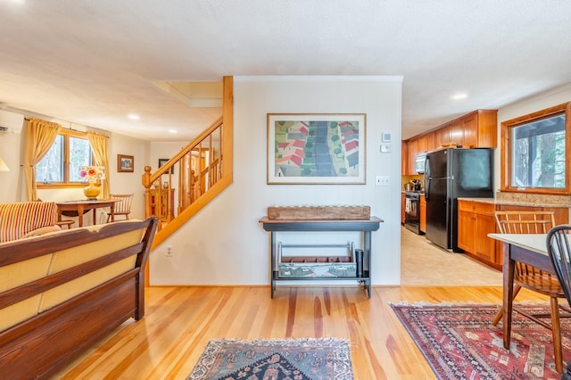 interior space featuring recessed lighting, black appliances, brown cabinets, and light wood-style flooring