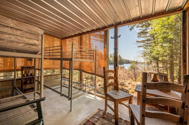 unfurnished sunroom featuring a water view