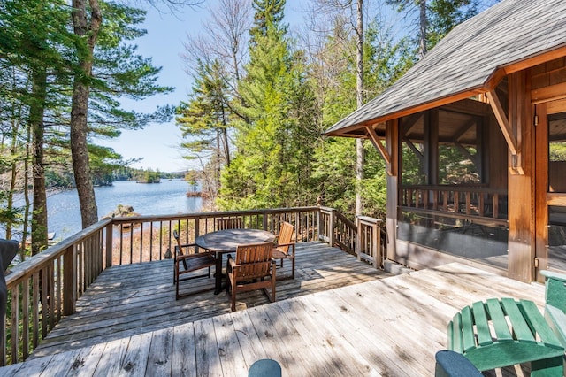 wooden deck featuring a water view and outdoor dining area