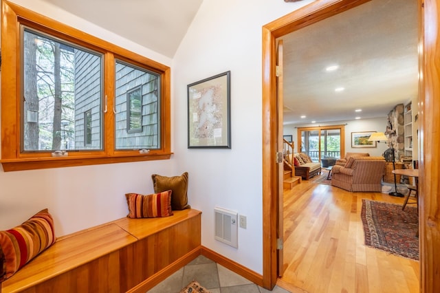 corridor featuring visible vents, wood finished floors, baseboards, lofted ceiling, and recessed lighting