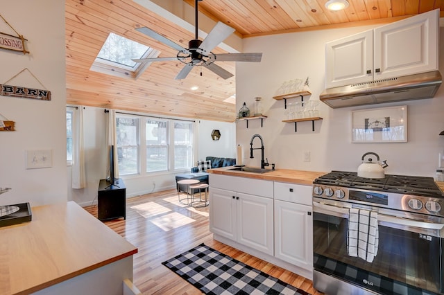 kitchen with white cabinets, a sink, stainless steel gas range oven, wooden ceiling, and under cabinet range hood